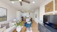 Located at 7135 Mount Zion Circle in Morrow, GA, this thoughtfully designed one-bedroom, one-bathroom residence offers a clean, modern aesthetic throughout its well-utilized single-floor layout. The open-concept living and kitchen area serves as the heart of the home, where light wood-tone flooring and crisp white walls create a bright, airy atmosphere. The kitchen is a standout feature, boasting two-tone cabinetry with white upper cabinets and natural wood lower cabinets, granite countertops, stainless steel appliances including a range, refrigerator, and dishwasher, and a large center island with pendant lighting — ideal for both cooking and casual dining. The living room offers generous natural light through sliding glass doors and a ceiling fan overhead, creating a comfortable, inviting retreat. The bedroom features a ceiling fan, a large window with exterior views, and direct access to a spacious walk-in closet outfitted with wrap-around wire shelving. The full bathroom includes a wood-toned vanity with granite countertop, a soaking tub with shower, and light wood flooring that carries throughout the space cohesively. Recessed lighting is found throughout, enhancing the clean, contemporary feel of this well-appointed residence.
