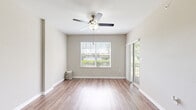 Located in Orlando's Falcon Parc community, this single-story home offers four bedrooms, two bathrooms, and a well-designed layout that maximizes functionality throughout. The open-concept living area features warm wood-look flooring, neutral-toned walls, and a ceiling fan, creating a bright and airy atmosphere with natural light streaming in through sliding glass doors. The kitchen is a standout feature, boasting rich dark cabinetry, granite-style countertops, stainless steel appliances including a refrigerator, microwave, and range, and a peninsula breakfast bar that connects seamlessly to the living space. The bedrooms are carpeted and each equipped with ceiling fans; several feature windows with views of surrounding greenery, adding a tranquil touch. The primary bathroom includes a dark-cabineted vanity with granite countertops, tile flooring, and a soaking tub with tile surround. A dedicated in-unit laundry room with wire shelving adds everyday convenience. Two closets and two hallways round out the layout. Clean white trim and panel doors are consistent throughout, contributing to a cohesive and well-maintained interior aesthetic.