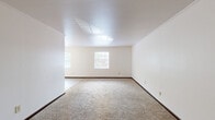 Located at 5521 Chatford Square in Columbus, Ohio, this single-floor, three-bedroom, one-bathroom home offers a practical and functional layout. The space is finished with neutral white walls, dark wood baseboards, and wall-to-wall carpeting throughout the bedrooms and living areas, creating a clean and consistent aesthetic.

The generously sized primary bedroom stands out as the largest room in the home, featuring two windows that invite abundant natural light and views of the surrounding greenery. The additional two bedrooms are well-proportioned, each with carpeted floors, natural light from windows with blinds, and dark sliding closet doors for storage. One bedroom also includes a ceiling fan with integrated lighting.

The galley-style kitchen is efficiently designed with dark brown cabinetry lining both walls, white appliances including a refrigerator, electric range, and dishwasher, and a double basin sink. A tile-patterned floor and white subway tile backsplash complete the kitchen's classic look, with direct access to a hallway connecting the rest of the home.

The bathroom is straightforward and functional, featuring a full tub-shower combination with a white surround, tile walls, and stone-look tile flooring. A hallway connects all rooms, providing a logical and easy-to-navigate flow throughout this compact yet comfortable home.