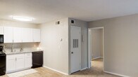 This renovated one-bedroom, one-bathroom unit at 365 Candlestick Way in Augusta, Georgia, offers a well-organized single-floor layout designed to maximize functionality. The kitchen features white shaker-style cabinetry, granite-look countertops, a tile backsplash, light wood-style flooring, and black appliances including a refrigerator, electric range, microwave, and dishwasher, creating a clean, modern aesthetic in a compact galley configuration.

The living area connects seamlessly to the kitchen and entry, continuing the light wood-style flooring and neutral wall tones. A ceiling fan overhead adds both comfort and practicality to the space. The bedroom is generously sized relative to the overall footprint, featuring plush carpeting, multiple windows with blinds that allow ample natural light and views of surrounding greenery, and a ceiling fan. A dedicated closet provides organized storage within the bedroom.

The bathroom is divided into a vanity area with a granite-topped cabinet and towel ring, and a separate water closet housing a tub-shower combination with white tile surround and a shower curtain. Neutral tones and updated fixtures throughout lend the unit a fresh, cohesive feel.