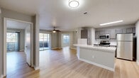 Located at 4659 Dawson Blvd in Atlanta, Georgia, this single-floor residence offers a thoughtfully designed open-concept layout that seamlessly connects the living, dining, and kitchen areas. Light hardwood-style flooring runs throughout the space, complementing the neutral gray walls and white trim for a clean, contemporary aesthetic. Textured ceilings and ceiling fans add functional character to the main living areas.

The kitchen is well-appointed with gray shaker-style cabinetry, white countertops, a subway tile backsplash, and a full suite of stainless steel appliances, including a refrigerator, electric range, and built-in microwave. A peninsula with a double sink provides additional prep space and opens to the living area, enhancing the open-concept feel.

The living room benefits from abundant natural light, with a sliding glass door leading to an outdoor balcony area offering views of the surrounding neighborhood. Bedrooms are generously sized, featuring large windows with blinds and ample closet space, including a walk-in closet with wire shelving. The bathroom is finished with large-format tile surrounds, a soaking tub, and updated vanity cabinetry. Overall, the space presents a fresh, move-in-ready interior with modern finishes throughout.