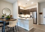 This single-floor residence in New Brunswick, NJ offers a thoughtfully designed layout with contemporary finishes throughout. The kitchen is a standout feature, equipped with rich dark-wood cabinetry, stainless steel appliances including a gas range, microwave, and French door refrigerator, complemented by crisp white quartz countertops and light wood-style flooring. A peninsula with an undermount sink provides additional workspace and casual dining opportunities.

The living area is bright and inviting, with large sliding glass doors that open to a private balcony, allowing ample natural light to fill the space. Multiple bedrooms offer comfortable retreats, each featuring plush carpeting, natural light from well-appointed windows with roller shades and sheer curtains, and neutral tones that create a calm, restful ambiance.

The bathrooms are elegantly finished with large-format tile flooring, dark-wood double vanities topped with white countertops, framed mirrors, and glass-enclosed walk-in showers with subway tile surround. The generous proportions of the bathrooms contribute to a spa-like atmosphere. Overall, the residence presents a cohesive modern aesthetic with warm wood accents, neutral palettes, and quality finishes that combine functionality with refined style.