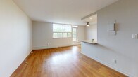 Located at 156 Fitch Street in Welland, Ontario, this well-appointed 2-bedroom, 1-bathroom unit offers a comfortable and functional layout across a single floor. Warm hardwood-style flooring flows consistently throughout the space, lending a cohesive and inviting feel to every room.

The open living room is bright and airy, featuring a large multi-pane window that fills the space with natural light and offers pleasant views of the surrounding tree-lined neighbourhood. A ceiling fan adds to the room's comfort, and a half-wall peninsula connects seamlessly to the kitchen.

The galley-style kitchen is efficiently designed, featuring white shaker cabinetry extending to the ceiling for ample storage, grey countertops, a subway tile backsplash, and a full suite of stainless steel appliances including a refrigerator, stove, microwave, and dishwasher. Recessed lighting keeps the space bright and functional.

Both bedrooms are well-sized with large windows, baseboard heating, and clean white walls. The primary bedroom includes a double sliding-door closet for generous storage. A hallway connects the rooms to the full bathroom, which features a sleek walk-in glass shower with chrome fixtures and a clean, all-white finish. The unit's elevated position provides treetop views of the surrounding Welland neighbourhood.