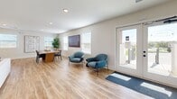 Located at 1101 SE 4th St in Oak Grove, Missouri, this single-floor clubhouse space for Rustic Heights offers a thoughtfully designed open-concept layout encompassing a living room, dining room, and kitchen within a comfortable and efficiently organized footprint. Light oak-toned luxury vinyl plank flooring flows seamlessly throughout, creating a warm, cohesive aesthetic that ties all areas together.

The living room serves as the heart of the space, anchored by a sleek linear fireplace set against a textured slat-panel accent wall. French doors open directly to an outdoor patio, flooding the interior with natural light and providing a seamless indoor-outdoor connection. Recessed ceiling lighting supplements the abundant natural light admitted through multiple white-framed windows fitted with clean plantation-style blinds.

The kitchen features flat-panel light wood cabinetry, a white quartz waterfall island with pendant lighting in brushed gold, subway tile backsplash, and stainless steel appliances. A second set of French doors in the kitchen offers additional outdoor access. The adjacent dining area accommodates a large communal table and benefits from natural light through multiple windows. The overall ambiance is modern, bright, and welcoming — a polished gathering space designed for community use.