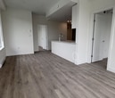 Located at Unit 621 – 14575 104 Avenue in Surrey, BC, this modern single-floor condo offers 570 square feet of thoughtfully designed living space. The open-concept layout seamlessly connects the living areas, creating a spacious and functional flow throughout the unit. Durable grey wood-tone laminate flooring runs consistently throughout, complementing the clean, neutral white walls and contemporary finishes.

The living area is bright and airy, benefiting from expansive floor-to-ceiling windows that flood the space with natural light and provide views of the surrounding neighbourhood's greenery and streetscape. Baseboard heating units are positioned along the exterior walls beneath the windows, and a wall-mounted air conditioning unit ensures year-round climate comfort.

The kitchen features white cabinetry, dark countertops, and a peninsula with an undermount sink, illuminated by track lighting overhead. It connects directly to the main living space, making it ideal for entertaining.

The bathroom is finished in a clean, contemporary style with large-format light grey tile, a vanity with stone-look countertop and undermount sink, a full-size toilet, and a walk-in shower. The unit also includes a private entry door with a secure lock. Overall, this condo presents a modern, move-in ready aesthetic suited for urban living.