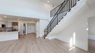Located at 800 S Harvard Blvd in Los Angeles' Koreatown neighborhood, this modern two-story space offers a thoughtfully designed open layout with clean lines and a bright, contemporary aesthetic throughout. The main level is anchored by a dramatic double-height living area with soaring ceilings and a wall of stacked windows that flood the space with abundant natural light. Light wood flooring runs continuously throughout both floors, lending warmth and visual continuity. The kitchen is well-appointed with stainless steel appliances, a electric range, integrated microwave, and refrigerator, complemented by a combination of white upper cabinetry and warm wood lower cabinets, open shelving, a stylish hexagonal tile backsplash, and a white quartz countertop. In-unit washer and dryer are conveniently located on the main level. A striking staircase with a sleek black metal railing leads to the upper floor, which features an open loft-style landing with windows, additional rooms, and a spacious walk-in closet with built-in shelving and hanging rods. Both bathrooms are finished with large-format floor tile, soaking tub and shower combinations with vertically stacked white tile surrounds, wood vanities, and illuminated LED mirrors, delivering a polished, modern feel throughout.