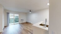 This 330 square foot studio apartment in Newport Beach offers a streamlined living experience. The open-concept layout maximizes space efficiency, with the living area seamlessly transitioning into the sleeping space. Gleaming hardwood floors run throughout, adding warmth and durability to the interior.

The living area is bright and airy, benefiting from large sliding glass doors that lead to a private balcony, offering outdoor space and potentially scenic views. A modern ceiling fan with integrated lighting provides both illumination and air circulation.

The bathroom features a clean, white design with a full-size bathtub and shower combination, ensuring practicality in the compact space. Built-in storage solutions, evident in the form of floor-to-ceiling white cabinets, offer ample room for personal belongings without cluttering the living area.

Climate control is handled by a wall-mounted air conditioning unit and baseboard heating, allowing for year-round comfort. The kitchenette, while not visible in the images, is likely integrated into the main living space, maintaining the studio's open feel.

This apartment is ideal for those seeking a minimalist lifestyle in a prime Newport Beach location, offering modern amenities in a well-designed, compact package.