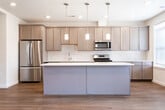 Located at 40 Old Short Hills Rd in Livingston, NJ, this two-floor residence offers a thoughtfully designed layout with contemporary finishes and generous living spaces throughout both levels. The kitchen serves as a central highlight, featuring gray shaker-style cabinetry, white quartz countertops, a classic subway tile backsplash, stainless steel appliances, and warm hardwood flooring. A large center island with pendant lighting above provides additional prep and seating space, creating an open, functional hub ideal for everyday living.

The bathrooms are finished with light large-format tile flooring, rich dark wood vanities topped with white countertops, and well-lit mirrors. One bathroom includes a soaking tub with a tiled surround and a window overlooking greenery, while another features a glass-enclosed walk-in shower. Natural light flows generously through the windows, enhancing the clean, bright aesthetic.

Bedrooms are carpeted and offer a neutral palette with vaulted or elevated ceilings, walk-in closets equipped with wire shelving systems, and ample square footage. A dedicated laundry area houses a full-size washer and dryer. The lower level provides a spacious carpeted bonus room with recessed lighting, suitable for a variety of uses.