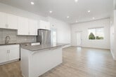 This thoughtfully laid-out 2-bedroom, 2-bathroom residence in Chubbuck, Idaho, offers a clean, modern aesthetic throughout its single-floor plan. Light-toned luxury vinyl plank flooring flows through the main living areas and hallways, complemented by crisp white walls and recessed lighting that keep the space bright and inviting.

The open-concept kitchen and living area serves as the heart of the home, featuring white shaker-style cabinetry, a gray tile backsplash, a central island with counter seating, and a full suite of stainless steel appliances including a range, microwave, and refrigerator. Adjacent to the kitchen, a dedicated area with warm wood-toned cabinetry provides additional storage and prep space.

The spacious primary bedroom is finished with plush carpeting, tall ceilings, and a large window that invites natural light and outdoor views. It is complemented by a generous walk-in closet with dual hanging rods. The second bedroom also features carpet flooring and a window with outdoor views, offering comfort and ample natural light.

Both bathrooms are finished in clean white with chrome fixtures, including a full tub-shower combo. Three closets throughout the unit provide excellent storage capacity. Two connecting hallways ensure smooth flow between all areas of the home, completing this well-organized and modern single-level residence.