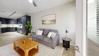 Located at 4949 N 7th St in Phoenix, AZ, this efficiently designed one-bedroom, one-bathroom unit offers a thoughtful layout across a single floor. The open-concept kitchen and living area form the heart of the space, with the kitchen showcasing sleek gray shaker-style cabinetry, white quartz countertops, a white tile backsplash, and a full suite of stainless steel appliances including a range, microwave, dishwasher, and French door refrigerator. Track lighting illuminates the space, while light wood-style flooring runs throughout the main living areas, adding warmth and continuity. The living room is bright and welcoming, featuring a ceiling fan, neutral gray walls, and a glass door that opens to a private outdoor area, allowing natural light to flow in freely. The bedroom offers plush carpeting, a ceiling fan, and a window with natural light, creating a calm and restful retreat. A built-in desk area provides a functional workspace within the bedroom. The bathroom features a clean, white tiled tub-shower combination with modern fixtures. A dedicated closet provides practical storage. The overall aesthetic is modern and neutral, offering a clean, move-in-ready living environment.