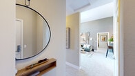 Located at Bridgepointe Parkway in San Mateo, CA, this two-bedroom, one-bathroom single-floor residence offers a well-organized layout designed for comfortable everyday living. The welcoming entryway hallway features a floating wood shelf and round mirror, opening naturally into a spacious living area with soaring ceilings, warm neutral tones, and a striking fireplace framed in tile. Large windows flood the living room with natural light and provide outdoor views, creating an airy and inviting atmosphere. The adjacent dining area is anchored by a bold mustard-yellow accent wall and a large window dressed in flowing curtains, adding warmth and character. The kitchen is efficiently designed with rich wood cabinetry, dark granite countertops, tile flooring, and a full suite of stainless steel appliances. The primary bedroom features vaulted ceilings, plush carpeting, a bold green accent wall, and a dedicated closet with built-in shelving. The second bedroom is equally comfortable with soft carpeting and hallway access. The bathroom is well-appointed with dark granite countertops, a wood vanity, a full tub-shower combination, and tile flooring. Throughout the home, soft carpet, neutral walls, and cohesive finishes create a harmonious and comfortable living environment.