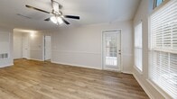 Located at 125 Parker Pl in LaGrange, GA, this well-appointed 1-bedroom, 2-bathroom single-story home offers a comfortable and functional layout. The combined kitchen and living area serves as the heart of the home, with the living room featuring light hardwood-style flooring, crown molding, a ceiling fan, vaulted ceilings, and a bank of windows that flood the space with natural light. A wainscoting detail along the walls adds a classic architectural touch. The galley-style kitchen is efficiently designed with white cabinetry, gray countertops, white appliances including a range and refrigerator, and matching hardwood-style flooring, providing ample storage and counter space. The spacious primary bedroom is carpeted for comfort and includes a ceiling fan, a window with outdoor views, and access to a dedicated bathroom featuring a single vanity with a large mirror and an adjacent walk-in closet with wire shelving. A second full bathroom includes a shower-tub combination. Throughout the home, six-panel doors, textured ceilings, and neutral tones create a clean, cohesive aesthetic. The 3D dollhouse view reveals an attached outdoor deck, extending the living space outdoors and completing this inviting home.