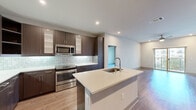 This well-appointed 2-bedroom, 3-bathroom single-floor residence offers a thoughtfully designed layout with modern finishes throughout. The open-concept kitchen and living area serves as the heart of the home, featuring a central island with a undermount sink, sleek quartz countertops, dark espresso cabinetry, a subway tile backsplash, and a full suite of stainless steel appliances including a refrigerator with ice maker, range, microwave, and dishwasher. Hardwood-style flooring runs throughout the main living areas, while an in-unit washer and dryer add convenience. Both bedrooms are generously sized, carpeted for comfort, and equipped with ceiling fans. Large windows fill each bedroom with natural light and provide views of the surrounding community. Each bedroom benefits from its own dedicated closet, with one featuring a full walk-in closet with built-in shelving and hanging rods. The bathrooms are finished with large-format tile flooring and include upscale details such as a glass-enclosed walk-in shower with decorative hexagonal tile accents and built-in shelving, a soaking tub, and a vanity with quartz countertops and wood-tone cabinetry. Two hallways connect the spaces efficiently, completing this clean and contemporary floor plan.