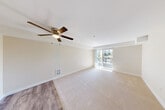 Located at 10710 Evergreen Way in Everett, WA, this two-bedroom, two-bathroom residence offers a well-organized single-floor layout designed for comfortable everyday living. The entrance leads into a hallway that connects the main living areas seamlessly. The living room is a generous, light-filled space featuring plush carpeting, a ceiling fan, and a large sliding glass door that opens to a private balcony with outdoor views of the surrounding greenery. The kitchen is positioned adjacent to the living area and features white cabinetry with gold-toned hardware, light granite-style countertops, white appliances, and a skylight that draws in natural light. Durable wood-look flooring runs through the kitchen and hallway areas. Both bedrooms are carpeted and well-proportioned, each offering natural light through windows and sliding-door closets for ample storage. The primary bedroom is notably spacious and bright. Both bathrooms are finished consistently, featuring light granite-style vanity countertops, undermount sinks, and full tub-shower combinations with wood-look flooring. The overall aesthetic is clean and neutral throughout, with warm beige tones and white trim creating a cohesive, move-in-ready ambiance.