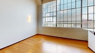 Suite 514 at 675 N Main St. in Winston-Salem, NC blends industrial character with modern finishes across a thoughtfully laid-out single floor. The main living area impresses with soaring ceilings, warm hardwood flooring, exposed brick accents, and oversized grid windows that flood the space with natural light and offer open city views. The kitchen is well-appointed with rich wood cabinetry, granite countertops, a mosaic tile backsplash, stainless steel appliances, and a peninsula that doubles as a breakfast bar. The bathroom features slate tile flooring, recessed lighting, and accessibility-friendly grab bars, offering a clean and functional design throughout.
