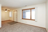 This single-floor unit offers a practical and comfortable layout designed to maximize usability throughout. The living area is generously sized, featuring neutral-toned carpet and a textured ceiling, with a large window that allows natural light to fill the space. A sliding glass door in one room opens to an outdoor area, further brightening the interior.

The kitchen is efficiently arranged with warm oak cabinetry providing ample storage, dark laminate countertops, a double-basin sink, and a full suite of black appliances including a refrigerator, range, and dishwasher. Dark tile flooring grounds the kitchen and adds a practical, easy-to-clean surface.

The bedrooms are carpeted and well-proportioned, each featuring neutral walls and adequate closet storage, including both sliding and louvered bi-fold closet doors. Natural light enters through windows dressed with vertical blinds, contributing to a bright and open feel.

The full bathroom is finished with dark stone-look tile flooring, a wide vanity with a white countertop and oak cabinetry, and a tub-shower combination. The layout flows cohesively throughout, maintaining a consistent, understated aesthetic across all rooms.