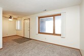 This single-floor unit offers a practical and comfortable layout designed to maximize usability throughout. The living area is generously sized, featuring neutral-toned carpet and a textured ceiling, with a large window that allows natural light to fill the space. A sliding glass door in one room opens to an outdoor area, further brightening the interior.

The kitchen is efficiently arranged with warm oak cabinetry providing ample storage, dark laminate countertops, a double-basin sink, and a full suite of black appliances including a refrigerator, range, and dishwasher. Dark tile flooring grounds the kitchen and adds a practical, easy-to-clean surface.

The bedrooms are carpeted and well-proportioned, each featuring neutral walls and adequate closet storage, including both sliding and louvered bi-fold closet doors. Natural light enters through windows dressed with vertical blinds, contributing to a bright and open feel.

The full bathroom is finished with dark stone-look tile flooring, a wide vanity with a white countertop and oak cabinetry, and a tub-shower combination. The layout flows cohesively throughout, maintaining a consistent, understated aesthetic across all rooms.