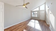 Located at 1930 Oberlin Dr in Maryland Heights, MO, this 2-bedroom, 1-bathroom home offers a thoughtfully designed single-floor layout. The combined living and dining area is a standout space, showcasing dramatic vaulted ceilings, warm hardwood-style flooring, and a ceiling fan overhead. Large windows and a glass-paneled front door flood the room with natural light, while direct access to a private balcony extends the living space outdoors. The galley-style kitchen is well-appointed with granite countertops, white cabinetry with modern hardware, and stainless steel appliances including a gas range and built-in microwave. The full bathroom features a granite-topped vanity with rich wood cabinetry, a medicine cabinet with mirror, and a tub/shower combination. Both bedrooms offer comfortable proportions with hardwood-style flooring; the primary bedroom includes a spacious reach-in closet. A dedicated laundry area with side-by-side units adds everyday convenience. Neutral tones and clean finishes throughout create a bright, move-in-ready atmosphere, while the entrance and hallway provide a smooth, organized flow between all rooms.