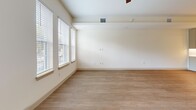 This well-appointed two-story home in Arlington, Texas offers three bedrooms and three bathrooms across two thoughtfully designed floors. The main level greets you with a bright, open living room featuring wide-plank hardwood-style flooring and large windows that flood the space with natural light and neighborhood views. The kitchen is a standout, showcasing a bold teal island with white quartz countertops, sage-toned cabinetry, stainless steel appliances, and stylish pendant lighting — a functional and eye-catching centerpiece. A half bath on the main floor features elegant marble-look tile flooring. Upstairs, the bedrooms are carpeted for comfort, with natural light streaming through window blinds. The primary bedroom includes access to a generously sized walk-in closet outfitted with multi-level hanging rods and built-in shelving on all sides. The full bathrooms are finished with floor-to-ceiling marble-style tile, teal vanity cabinetry, and white countertops, lending a clean, modern aesthetic. A dedicated laundry area with an in-unit front-load washer and dryer, plus overhead shelving, adds everyday convenience. Throughout, the home maintains a neutral, warm palette that creates a cohesive and inviting atmosphere.