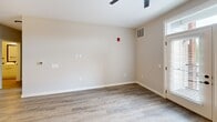 Located in Lancaster, PA, this well-appointed single-floor unit offers a thoughtfully designed layout across two bedrooms and a combined kitchen/living space. The open-concept living area is bright and airy, featuring warm hardwood-style flooring, neutral walls, and a ceiling fan overhead. French doors with transom windows flood the room with natural light and provide access to the outdoors, enhancing the sense of openness throughout.

The kitchen is a standout feature, showcasing sleek flat-front white cabinetry extending to the ceiling, a white subway tile backsplash, and a large center island with a white countertop, undermount sink, and built-in microwave. Stainless steel appliances — including a gas range and French door refrigerator — complete the modern aesthetic, complemented by a stylish pendant light and track lighting above.

Both bedrooms offer a comfortable, carpeted retreat with soft neutral tones and ample natural light from large windows. The primary bedroom is generously sized, while the second bedroom provides a versatile secondary space, each with views to the surrounding Lancaster landscape.

This unit combines clean, contemporary finishes with a practical layout, making it an ideal residence in the heart of Lancaster, PA.
