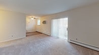 Located at 1141 Pawlings Rd in Norristown, PA, this single-floor unit offers a practical and comfortable layout with a blend of hardwood-style and carpeted flooring throughout. The open kitchen is well-appointed with warm wood cabinetry, stainless steel appliances including an electric range, over-the-range microwave, and a full-size refrigerator, complemented by a ceiling fan overhead and a baseboard heating system. The kitchen flows naturally into the adjacent living areas, creating an easy, connected layout. The main living area features plush carpeting, a ceiling fan with light fixture, a wall-mounted air conditioning unit, and a sliding glass door dressed with vertical blinds that brings in natural light and provides access to the outdoors. A second carpeted room offers generous space, natural light through a window, wall-unit air conditioning, and baseboard heat. The bedroom is a well-sized, carpeted retreat with neutral walls, baseboard heating, and a set of double louvered closet doors providing ample storage. Throughout the unit, the clean, neutral color palette and functional features create a bright and livable environment suited for everyday comfort.