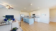 This two-story home offers a thoughtfully designed layout that balances open communal spaces with comfortable private retreats. The heart of the home is a bright, open-concept kitchen and living area, where light hardwood-style flooring flows seamlessly throughout. The kitchen is appointed with crisp white shaker cabinetry, granite countertops featuring a neutral stone pattern, a large central island with seating and a built-in sink, and a full suite of stainless steel appliances including a refrigerator with ice dispenser, microwave, and range. Recessed lighting illuminates the space, enhancing the clean, modern aesthetic.

The bedrooms are generously sized, each featuring the same warm hardwood-style flooring, soft neutral walls, and ample closet space — including a spacious walk-in closet with wire shelving in the primary suite. Multiple windows bring in natural light and outdoor views throughout the upper level. Bathrooms are finished with granite-topped vanities, wood-look flooring, and a full tub-shower combination. A convenient half bath is also present on the main level. A dedicated laundry room accommodates a full-size washer and dryer with overhead shelving. The overall ambiance is clean, modern, and move-in ready.