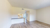 Located at 744 Spring West Rd in Orlando, Florida, this single-floor residence offers a well-organized and functional layout designed for comfortable everyday living. The open living area is finished with light-toned wood-look flooring that extends throughout the main spaces, giving the interior a clean and cohesive appearance. Textured ceilings add a classic touch throughout.

The kitchen is efficiently designed with white cabinetry, granite-style countertops, and a suite of white appliances including a refrigerator, range, and dishwasher. A pass-through counter connects the kitchen to the living area, creating an open sightline that enhances the sense of space. The dining area sits adjacent, complete with a built-in countertop shelf — a practical detail for casual dining or additional workspace.

The bedroom is a comfortable retreat, featuring plush wall-to-wall carpeting and access to a dedicated closet space, providing ample storage. Warm, neutral wall tones throughout the home contribute to a bright and welcoming atmosphere.

The bathroom is well-appointed with white cabinetry, a granite-style vanity countertop, a wide mirror, and wood-look flooring that ties seamlessly into the rest of the home's design. Overall, this residence presents a tidy, move-in-ready interior with consistent finishes and a practical floor plan suited to a variety of lifestyles.
