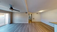 This single-floor residence offers a clean, modern aesthetic carried consistently throughout every room. The open living area features wood-style plank flooring and a ceiling fan, with a sliding glass door that invites natural light and provides direct access to an outdoor patio. The space flows naturally into a central hallway connecting the remaining rooms of the home.

The kitchen is well-equipped with stainless steel appliances, including a gas range, over-the-range microwave, refrigerator, and dishwasher. White shaker-style cabinetry reaches toward the ceiling, complemented by a neutral countertop, subway tile backsplash, and a built-in sink. Track lighting overhead adds a contemporary touch.

The bedrooms are comfortably sized, each featuring wood-style flooring, ceiling fans, and windows fitted with horizontal blinds that allow for adjustable natural light. One bedroom includes a closet with bifold doors, providing practical storage.

Two full bathrooms serve the home, both finished with wood-style flooring, tub-shower combinations, and vanities featuring modern cabinetry with clean white countertops and well-lit mirrors. The overall palette of warm neutrals and light tones gives the home a bright, cohesive, and move-in-ready feel.
