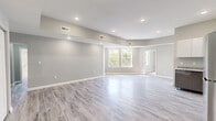 This thoughtfully designed two-bedroom, two-bathroom single-floor home at 770 Ridgeway Ave in Cincinnati, Ohio offers a clean, modern aesthetic with consistent finishes throughout. Light gray wood-look tile flooring flows seamlessly across all rooms, creating a cohesive and contemporary feel. The open kitchen and living area forms the heart of the home, featuring high-gloss white upper cabinetry, two-tone gray lower cabinets, granite countertops, and stainless steel appliances including a gas range and full-size refrigerator. Recessed lighting and an open sightline to the living space make this an inviting area for daily living. The spacious primary bedroom includes a tray ceiling, ceiling fan, and dual closets, with ample natural light. The second bedroom benefits from large windows with views of surrounding trees, adding a sense of warmth and greenery. Both bathrooms are well-appointed — one features a soaking tub with bold marble-look tile surround and matte black fixtures, while the other includes a glass-enclosed shower. Soft gray walls and crisp white trim throughout lend the entire home a fresh, move-in-ready feel. A hallway and entry area with built-in closet storage complete this well-organized layout.