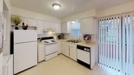 This two-story, 2-bedroom, 1.5-bathroom residence offers a practical and comfortable layout across two well-defined levels. The main floor features a carpeted living area with a staircase accented by decorative wrought-iron railings, leading to an adjacent kitchen. The kitchen is outfitted with white cabinetry, a electric range, refrigerator, dishwasher, and a double sink beneath a window that brings in natural light. A convenient half-bathroom is also located on this level, featuring a vanity with a large mirror and overhead lighting.

Upstairs, two carpeted bedrooms each offer ceiling fans with integrated lighting and windows fitted with horizontal blinds, allowing for adjustable natural light and views to the outdoors. The full bathroom on this level includes a combined tub and shower unit with tile flooring, a toilet, and a vanity with counter space. Throughout the unit, the neutral color palette of cream and white walls creates a clean, cohesive aesthetic. The carpeted floors in the living and sleeping areas add warmth, while the overall layout maximizes the use of the available square footage for comfortable day-to-day living.