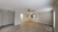 This single-floor 1-bedroom, 1-bathroom residence offers a thoughtfully designed layout with a clean, modern aesthetic throughout. The spacious living area is finished with wood-look luxury flooring, crown molding, and a ceiling fan, while a built-in mirrored wall feature adds depth and a touch of elegance. Two windows allow natural light to fill the room, creating a bright and welcoming atmosphere.

The kitchen is outfitted with white cabinetry featuring brushed nickel hardware, quartz countertops, a subway tile backsplash, and stainless steel appliances including a refrigerator, range, and microwave — providing both style and functionality.

The bedroom is carpeted for comfort and includes dual closets offering generous storage, along with a ceiling fan and a window that brings in natural light. The bathroom features a wide vanity with quartz countertops, white cabinetry, a well-lit mirror, and a full tub-shower combination with clean white tile surround.

A dedicated laundry area with side-by-side washer and dryer, upper cabinetry, and additional counter space adds exceptional convenience. The neutral color palette and consistent finishes throughout create a cohesive, move-in-ready living environment.