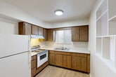 Located at 160 Manitou Ln in Lake Orion, Michigan, this single-floor, one-bedroom, one-bathroom unit offers a practical and well-organized layout. Light wood-tone vinyl flooring flows consistently throughout the space, lending a clean, cohesive look to every room.

The combined kitchen and dining area is equipped with warm wood-toned cabinetry providing ample upper and lower storage, a white appliance suite including a range and refrigerator, light countertops, and a window above the sink that brings in natural light. A pass-through window connects the kitchen to the living area, creating an open, communicative feel between the two spaces.

The living room is bright and open, with neutral walls and a ceiling fan with light fixture overhead. A large window with vertical blinds allows natural light to fill the room, while a baseboard heating unit ensures comfort year-round.

The bedroom is a generously sized room featuring light wood flooring, a ceiling fan, a large closet with wood-panel doors, and a window that overlooks the exterior. The unit also includes three closets total, offering notable storage capacity.

The bathroom is clean and functional, featuring a full tiled tub-shower combo with grab bars, and wood-tone flooring. A hallway connects all areas of the unit efficiently, completing this well-appointed single-floor layout.