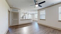 Located at 24 Riverpoint Pl in Rome, GA, this well-appointed 3-bedroom, 2-bathroom single-floor residence offers a thoughtfully designed open-concept layout. The combined living, dining, and kitchen area serves as the heart of the home, featuring warm hardwood-style flooring, multiple windows with natural light, and ceiling fans throughout. The kitchen is outfitted with crisp white shaker cabinetry, a classic subway tile backsplash, granite countertops, a peninsula with an undermount sink, stainless steel appliances, and track lighting overhead. The spacious living and dining area flows seamlessly from the kitchen, creating an ideal space for both entertaining and everyday living. Each of the three bedrooms is carpeted and includes a ceiling fan and closet access, with the primary bedroom offering generous proportions. The two bathrooms feature granite-topped vanities, white cabinetry, and hardwood-style flooring. Additional spaces include a laundry room, utility room, and five closets providing ample storage. The covered patio extends the living space outdoors, offering wood-plank decking, decorative railings, and open views of the surrounding greenery — a tranquil retreat ideal for relaxing or entertaining.
