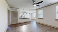 Located at 24 Riverpoint Pl in Rome, GA, this well-appointed 3-bedroom, 2-bathroom single-floor residence offers a thoughtfully designed open-concept layout. The combined living, dining, and kitchen area serves as the heart of the home, featuring warm hardwood-style flooring, multiple windows with natural light, and ceiling fans throughout. The kitchen is outfitted with crisp white shaker cabinetry, a classic subway tile backsplash, granite countertops, a peninsula with an undermount sink, stainless steel appliances, and track lighting overhead. The spacious living and dining area flows seamlessly from the kitchen, creating an ideal space for both entertaining and everyday living. Each of the three bedrooms is carpeted and includes a ceiling fan and closet access, with the primary bedroom offering generous proportions. The two bathrooms feature granite-topped vanities, white cabinetry, and hardwood-style flooring. Additional spaces include a laundry room, utility room, and five closets providing ample storage. The covered patio extends the living space outdoors, offering wood-plank decking, decorative railings, and open views of the surrounding greenery — a tranquil retreat ideal for relaxing or entertaining.