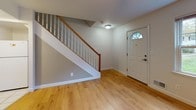Located at 3 Jefferson Ct in Fall River, Massachusetts, this two-floor home offers a straightforward, functional layout with clean finishes throughout. The entryway greets visitors with warm wood-style laminate flooring and a staircase featuring a wood handrail and white balusters, setting a welcoming tone from the moment of arrival. Natural light filters in through an arched window above the front door.

The kitchen is well-equipped with light wood cabinetry, dark granite-style countertops, and tile flooring. It includes a gas range, dishwasher, refrigerator, and over-the-range microwave, alongside a peninsula that provides additional counter space. A secondary entry door with a small window adds convenience and additional light.

The living areas on the upper floor are carpeted and brightened by multiple windows with outdoor views of the surrounding neighborhood. Ceiling fans are present in several rooms, contributing to comfort year-round. One bedroom features wood-style flooring and a spacious closet.

The bathroom is finished in white tile, featuring a tub-shower combination, a window for natural ventilation, and a vanity with ample storage. Throughout the home, neutral wall tones and clean white trim create a cohesive, move-in ready aesthetic.