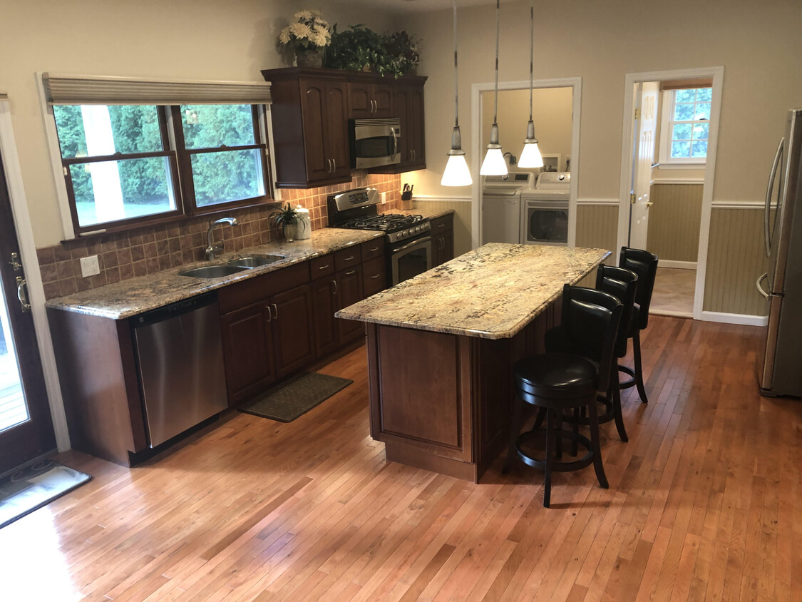 Large kitchen area with center island, granite, cherry wood cabinets, pendant & high lights - 42 Pleasant Ave