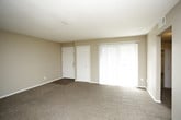 This single-floor unit offers a practical and comfortable layout designed for everyday living. The living areas are finished with neutral-toned carpet and warm beige walls, creating a cohesive and understated aesthetic throughout. Ceiling fans are present in the main living spaces, promoting airflow and comfort. Natural light filters in through windows, enhancing the overall brightness of the interior.

The kitchen is well-appointed with rich wood cabinetry extending to the upper walls, offering generous storage capacity. Light granite-style countertops provide ample workspace, complemented by a double stainless steel sink, a gas range, a dishwasher, and wood-look flooring that adds warmth to the space.

Multiple bedrooms feature plush carpeting and bifold or panel closet doors concealing roomy closets fitted with hanging rods and shelving. One bedroom notably includes a walk-in closet for enhanced storage.

Two bathrooms serve the unit, each featuring wood-look tile flooring, dark wood vanities, and granite-style countertops. One bathroom includes a tub-shower combination, while the other features a dedicated linen or storage closet. Textured ceilings are consistent throughout the unit, adding a subtle design detail to the overall finish.