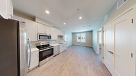 Located at 1639 E Tropicana Ave in Las Vegas, NV, this two-bedroom, two-bathroom residence offers a thoughtfully designed single-level layout. Light wood-style flooring runs throughout, creating a cohesive and contemporary feel across all rooms.

The kitchen is a standout feature, outfitted with white shaker cabinetry extending to the ceiling, light gray subway tile backsplash, white quartz countertops, and a full suite of stainless steel appliances including a side-by-side refrigerator with ice and water dispenser, electric range, built-in microwave, and dishwasher. The kitchen flows naturally into the open living area, which is brightened by a large window that invites natural light.

Both bedrooms are comfortably sized, with the primary bedroom offering a ceiling fan and a window with outdoor views. The unit includes three closets, providing generous storage throughout, including a dedicated walk-in closet accessible from one of the bathrooms. Each bathroom features a tub/shower combination with clean white tile surround, a vanity with undermount sink, and wood-style flooring. Recessed lighting and neutral warm-toned walls complete the clean, move-in-ready aesthetic of this Las Vegas residence.