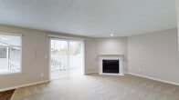 Located at 11912 SE 7th St in Vancouver, Washington, this single-floor unit offers a well-organized layout designed for comfortable everyday living. An entry hallway with durable wood-look flooring provides a smooth transition into the main living areas.

The living room is a standout space, centered around a classic white-mantled fireplace and bathed in natural light through a large sliding glass door fitted with vertical blinds, which opens to a private patio with outdoor views. A ceiling fan adds to the comfort of this bright, open area, which features plush neutral carpeting throughout.

The kitchen is equipped with stainless steel appliances—including a range, refrigerator, and dishwasher—complemented by white cabinetry, gray countertops, and warm wood-look flooring. The space is functional and efficiently arranged for daily use.

The bedrooms are generously sized, each with soft carpeting, neutral-toned walls, and windows that bring in natural light and views of the surrounding neighborhood. One bedroom includes direct access to a closet area. The bathroom features a clean, white tub-shower combination with chrome fixtures and wood-look flooring.

Throughout the unit, textured ceilings, neutral wall tones, and consistent finishes contribute to a cohesive, move-in-ready atmosphere.