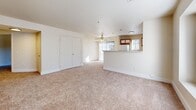 Located at 7929 W Mansfield Pkwy in Lakewood, Colorado, this single-floor, 2-bedroom, 1-bathroom unit offers a practical and efficiently designed layout. The combined kitchen and living area forms the heart of the space. The living room features plush neutral carpet, a ceiling fan, and a large front-facing window that draws in generous natural light. A front entry door opens directly into this area, creating a welcoming entry point.

The kitchen is well-equipped with wood-accented cabinetry featuring white panel fronts, a full suite of white appliances including a refrigerator, electric range, and built-in microwave, as well as a dishwasher. A peninsula with a wood-finished counter and an integrated sink separates the kitchen from the living area, adding both functionality and definition to the open layout. Durable wood-style flooring runs throughout the kitchen.

Both bedrooms are carpeted in the same neutral tones as the living room and include closets with sliding or bifold doors. The primary bedroom offers a comfortable footprint with windows providing natural light. The shared full bathroom features wood-style flooring, a tiled tub-shower combination, a vanity with cabinet storage, and a lighted mirror. A hallway connects the private areas of the unit to the main living spaces.