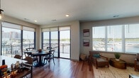 Located at 901 Nutt St in Wilmington, NC, this modern single-floor residence offers a sophisticated living experience with stunning marina views. Rich hardwood flooring flows throughout the entire space, anchoring a contemporary design aesthetic defined by neutral tones and clean lines.

The open-concept layout connects the living, dining, and kitchen areas seamlessly. The living room is well-lit by large windows overlooking the marina, providing a bright and welcoming atmosphere. The kitchen features high-gloss white cabinetry, light quartz countertops, a classic subway tile backsplash, and stainless steel appliances, offering both style and functionality.

The dining area is positioned adjacent to floor-to-ceiling sliding glass doors that open onto a private balcony, framing expansive views of the marina and waterway — an ideal setting for entertaining or relaxed dining.

The primary bedroom enjoys direct marina views through wide windows and includes a ceiling fan, walk-in closet, and a well-appointed en-suite bathroom. The en-suite features a glass-enclosed shower, LED-backlit mirror, and white modern vanity. A second bedroom offers city-facing views and natural light. A secondary bathroom with matching modern finishes provides additional convenience. The overall ambiance is polished, coastal, and move-in ready.