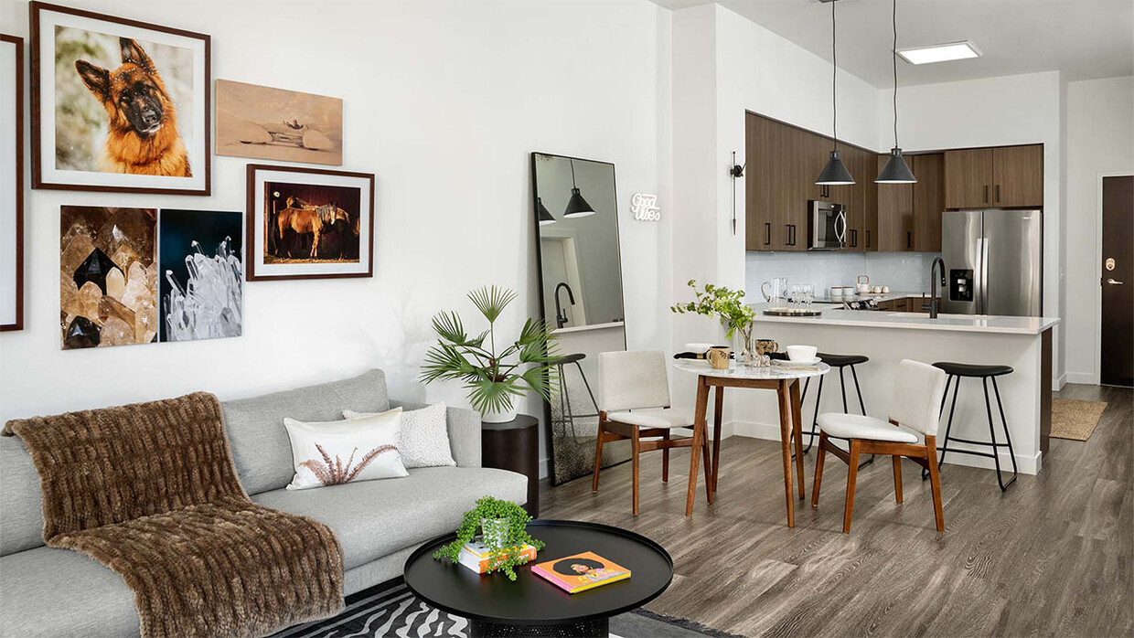 Cocina del apartamento con electrodomésticos de acero inoxidable, comedor y sala de estar con pisos de madera. - Griffis Cherry Creek North