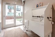 Pet grooming station with washing tub and doors leading to an outdoor area.