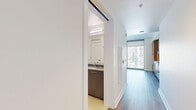 This 350 square foot apartment, situated on the 15th floor of 399 Fremont St in San Francisco, exemplifies modern urban living. The space features an open-plan layout that maximizes the compact footprint. The kitchen area boasts a combination of white and warm wood cabinetry, stainless steel appliances, and a striking view of the city skyline through floor-to-ceiling windows. Light wood flooring throughout creates a sense of continuity and warmth.

The apartment includes two bathrooms, both finished with neutral-toned tiles and modern fixtures. One bathroom showcases a spacious shower with a built-in niche for toiletries. The hallway provides access to a closet, enhancing the unit's storage capabilities.

The bedroom area, while not separated by walls, is clearly defined within the open layout. It features the same expansive city views and access to natural light. The overall design emphasizes clean lines, a neutral color palette, and high-end finishes, creating a sophisticated and functional living space that takes full advantage of its prime urban location and panoramic vistas.