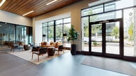 Located at 200 Market St in Montvale, New Jersey, this sophisticated single-floor commercial space delivers a premium environment defined by thoughtful design and high-end finishes. The grand entry lobby sets an immediate tone with soaring ceilings clad in warm wood slat panels, expansive floor-to-ceiling glazing, and large-format tile flooring. Natural light pours in through the generous window walls, offering views of the surrounding greenery and neighboring buildings.

The welcoming lounge areas feature curated furnishings, including leather sofas, wood-framed accent chairs, and sculptural coffee tables arranged atop area rugs, creating an inviting yet professional atmosphere. A spacious café and dining area is equipped with a beverage station, pendant lighting, and vibrant seating — ideal for informal gatherings or casual work sessions.

A dedicated corridor with frosted glass partitions and bold textured wall finishes leads to a well-equipped fitness center, visible through glass walls. Additional collaborative zones throughout the floor offer banquette-style seating alongside individual tables, framed by dark-toned wood ceilings and glass dividers. Art installations and greenery are integrated throughout, lending warmth and character. The space consistently balances modern architectural precision with approachable, functional design.