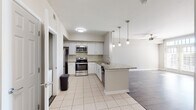 Located at 144 Ponce de Leon Ave NE in Atlanta's vibrant Ponce de Leon corridor, this single-floor residence offers a well-designed open-concept layout that seamlessly connects the kitchen, dining, and living areas. The kitchen is appointed with white cabinetry, granite countertops, a subway tile backsplash, and a full suite of stainless steel appliances including a refrigerator, electric range, and over-the-range microwave. A peninsula with pendant lighting provides additional prep and seating space, anchoring the transition into the main living area. The spacious living room features durable wood-look flooring, crown molding, a ceiling fan, and a set of glass-paneled doors that invite an abundance of natural light while offering access to the outdoors. The bathroom is finished with a granite-topped white vanity, wood-look flooring, and a tiled walk-in shower and tub combination. A dedicated in-unit laundry closet with a stacked washer and dryer adds everyday convenience. Light, neutral tones throughout the space create a clean and welcoming ambiance well-suited to a variety of décor styles.