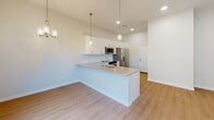 Located in Phoenix, AZ, this thoughtfully designed two-story residence offers three bedrooms, three bathrooms, and a functional layout spread across two floors. The main level features an open-concept kitchen appointed with crisp white shaker cabinetry, a subway tile backsplash, quartz countertops, a peninsula with an undermount sink, and a full suite of stainless steel appliances including a French door refrigerator, electric range, and over-the-range microwave. Pendant lighting and recessed fixtures add a modern touch to the space. The main floor also includes a dedicated laundry room with a full-size washer and dryer. Light wood-look flooring flows throughout both levels, contributing to a clean and cohesive aesthetic. Upstairs, three well-proportioned bedrooms each feature ceiling fans, natural light from sliding windows, and access to closets. The spacious primary bedroom connects to a generous walk-in closet with built-in shelving and hanging rods. The bathrooms are finished in a clean, contemporary style with white vanity cabinetry, quartz countertops, and light wood flooring. A staircase connects both floors, complementing the home's bright, neutral palette and modern design sensibility throughout.