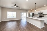 Located at 325 E Green St in West Branch, Iowa, this modern multi-floor home offers 2 bedrooms, 3 bathrooms, and a thoughtfully designed layout spread across three levels. The ground floor houses a spacious two-car garage with a concrete floor and automatic opener, along with additional entry space. The main living floor is the heart of the home, featuring an open-concept kitchen and living area bathed in natural light. The kitchen is outfitted with white shaker-style cabinetry, stainless steel appliances, a large center island with white quartz countertops, and stylish pendant lighting. The adjoining living area extends to a private balcony through sliding glass doors, offering pleasant outdoor views. Durable wood-look flooring runs throughout the main level, complemented by recessed lighting and a ceiling fan. A convenient half bathroom completes this floor. The upper level hosts both bedrooms, each with wood-look flooring and closet space. The generously sized primary bedroom features vaulted ceilings, multiple windows for abundant natural light, and a ceiling fan. The upper-level bathrooms are well-appointed with rich wood-toned vanities, white quartz countertops, black hardware accents, and clean-lined walk-in showers, reflecting a cohesive and modern design aesthetic throughout.