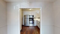 This single-story residence in Memphis, Tennessee offers a well-organized two-bedroom, one-bathroom layout with consistent hardwood flooring running throughout every room, lending warmth and cohesion to the entire space. The living area greets residents at the entrance, featuring natural light through a window with blinds and clean, neutral-toned walls with white trim detailing.

The kitchen stands out as a notable highlight, having been thoughtfully updated with white shaker-style cabinetry, stainless steel appliances including a refrigerator, range, microwave, and dishwasher, and quartz countertops. A decorative penny-tile mosaic backsplash adds a stylish, modern touch, while dark hardwood floors ground the space with a classic contrast.

Both bedrooms are comfortably sized with neutral gray walls, hardwood floors, ceiling fans with light fixtures, and windows fitted with blinds to allow natural light while maintaining privacy. The rooms connect through a straightforward, efficient layout as shown in the floor plan view.

The bathroom features a white vanity with updated cabinetry, a tiled tub-shower combination, and hardwood flooring, maintaining a clean and functional aesthetic consistent with the rest of the home. Overall, the space presents a cohesive blend of updated finishes and practical design.