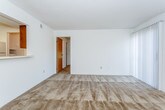 This single-floor residence presents a straightforward and functional layout designed for comfortable everyday living. The spacious living area serves as the heart of the home, finished with neutral-toned wall-to-wall carpeting and textured ceilings throughout. A pass-through window connects the living space to the kitchen, enhancing the sense of openness while maintaining a defined separation between the two areas.

The galley-style kitchen is efficiently arranged with warm wood-toned cabinetry lining both walls, light-colored countertops, tile flooring, and white appliances including a range, refrigerator, and dishwasher. A doorway at the end of the kitchen provides additional access to other areas of the unit.

Two carpeted bedrooms offer comfortable retreats, each featuring ceiling fans with light fixtures and windows that allow natural light to filter in. The primary bedroom includes direct access to an en-suite bathroom, while a second full bathroom serves the remaining spaces. Both bathrooms are equipped with wood-toned vanities, light countertops, and standard fixtures, with the second bathroom featuring a tub-shower combination with white tile surround.